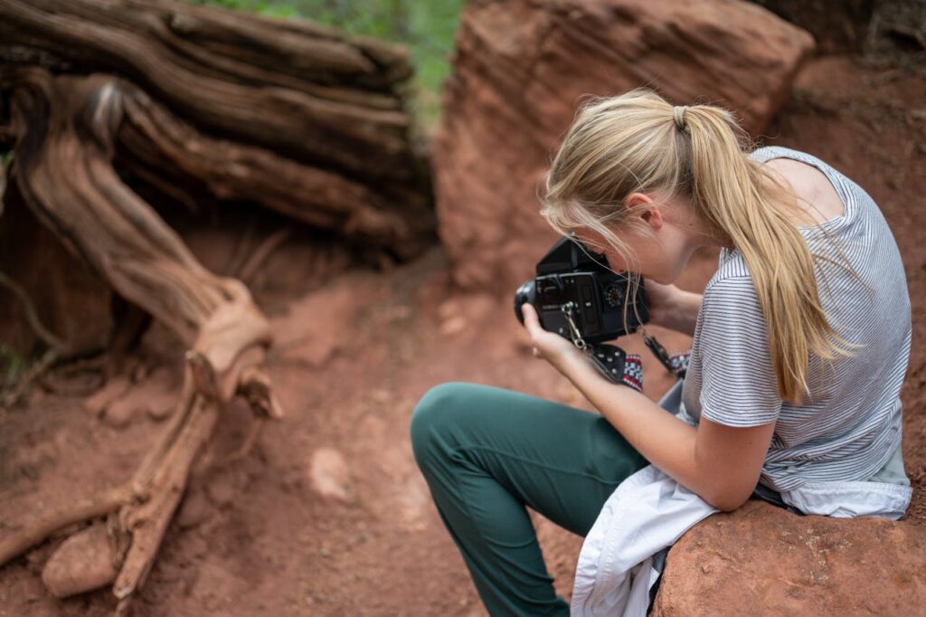 The Art of Drawing Readers In: Your attractive post title goes here Woman photographing red rocks, embracing nature photography in a desert setting.
